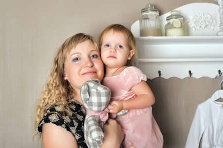 Blond women holding in her arms a little girl.の写真素材