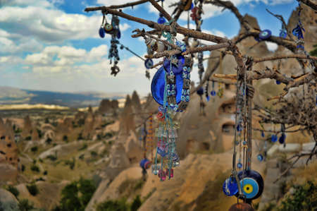 Evil eye charms hang from a bare tree in Cappadocia, Turkey.の写真素材