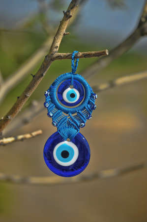 Evil eye charms hang from a bare tree in Cappadocia, Turkey の写真素材