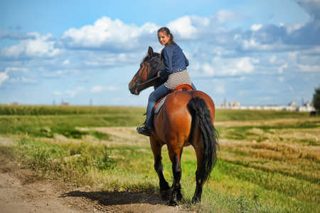 girl in jeans suit on a horse