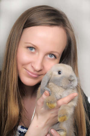 Blonde woman with a rabbit in the hands.の写真素材
