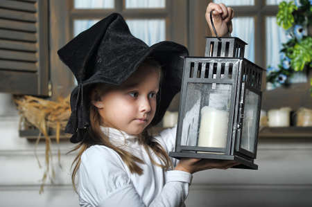 Girl with lanterns in witch hatの写真素材