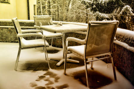 Snow-covered chairs on the terrace.の写真素材