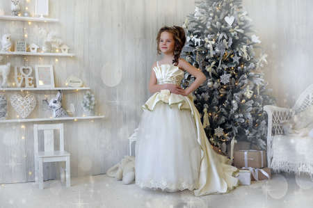 Winter princess in white dress at the Christmas tree.の写真素材