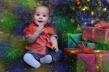 little boy at the Christmas tree with giftsの写真素材