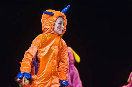 Children in funny colored overalls aliens dancing on stageのeditorial素材