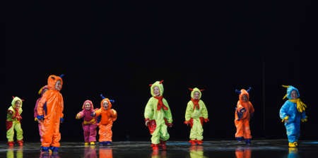 Children in funny colored overalls aliens dancing on stageのeditorial素材