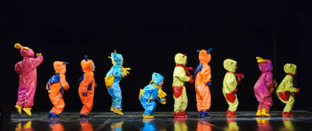 Children in funny colored overalls aliens dancing on stageのeditorial素材