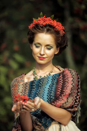 Portrait of a woman with rowan in the hair near the tree.の写真素材