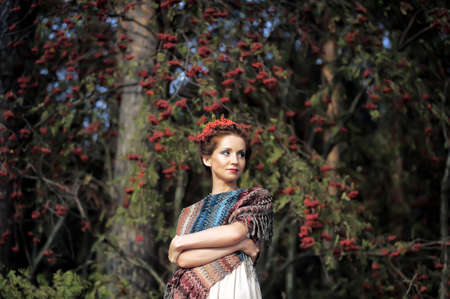 Portrait of a woman with rowan in the hair near the tree.の写真素材