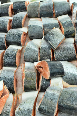 Pieces of a salmon with ice on a shop counter.のeditorial素材