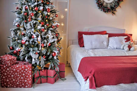 Interior with a bed next to the Christmas tree.の写真素材