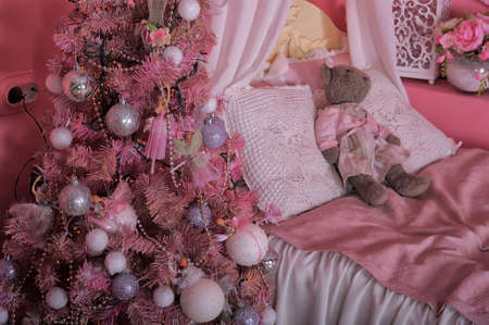 Interior of children\'s room in pink tones with Christmas tree.の写真素材