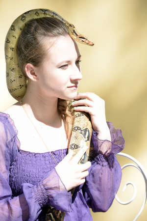 Teen girl in a purple dress holding a python