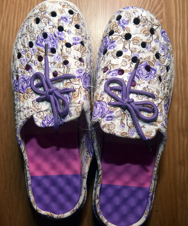 Colored slippers on the wooden background.