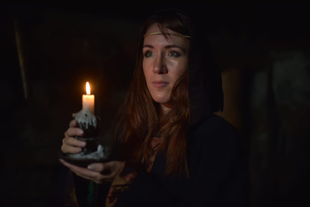 Portrait of a woman in the dark with a candle in hands.の写真素材