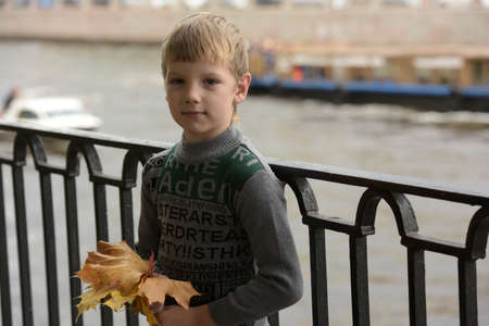 Portrait of boy child with autumn leaves.の写真素材