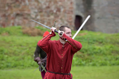 Russia, Ivangorod 01.08,2015 Festival of medieval reconstruction "Russian fortress", Fencing on swords in medieval costumesのeditorial素材