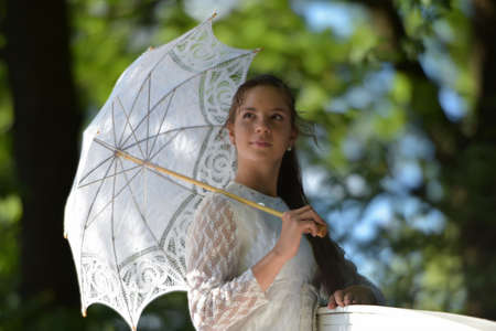 girl in white dress with openwork vintage umbrellaの写真素材