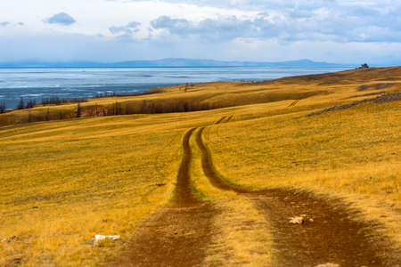 Track winding back roads in the mountains. Dirt road on Olkhon island in lake Baikal. For guide to Russia.の写真素材