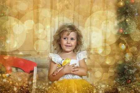 young princess in a smart yellow with a white dress in christmasの写真素材