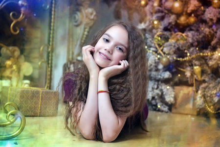 brunette girl lying on the floor near the christmas treeの写真素材