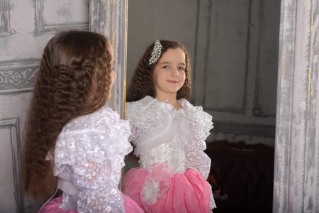 Princess girl in white with a pink dress near the mirror, reflection