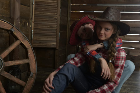 Boy and girl, brother and sister in cowboy hats