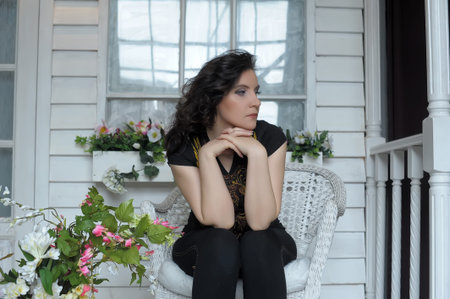 sad middle-aged brunette sitting on the veranda