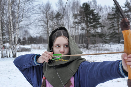 Russia, Svargas 25,11,2014 A girl shoots in the winter from a bow at the festival of medieval...