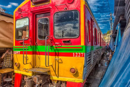 SAMUT SONGKHRAM, THAILAND - 07.07, 2019 : Tourists take photo at the train running through the most popular spot Talad Rom Hup or Umbrella market at Mae Klong railway stationのeditorial素材