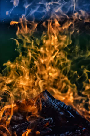 bonfire and flames against a dark sky in the fieldの写真素材