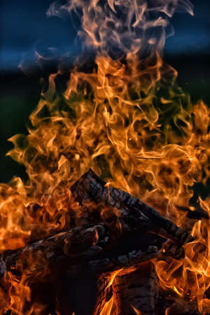 bonfire and flames against a dark sky in the fieldの写真素材