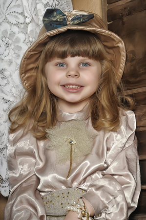 little girl in a hat and a blouse with pants in a vintage interior
