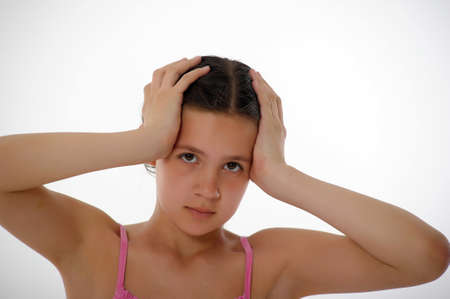 young girl in pink clutching her head childの写真素材