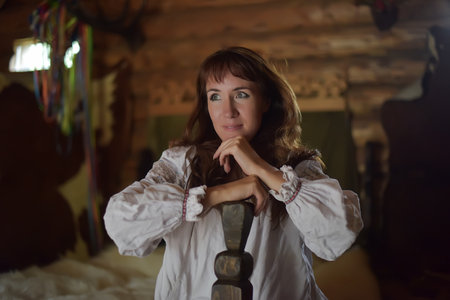 brunette with medieval simple dress sits on the bedの写真素材