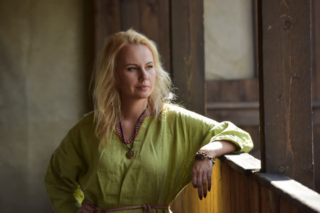 blonde in a simple green medieval viking dressの写真素材