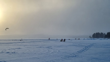 Winter landscape. A view of the frozen snow-covered lake. Forest in the background. Stormy evening clouds. Onega lake, Karelia, Russiaの写真素材