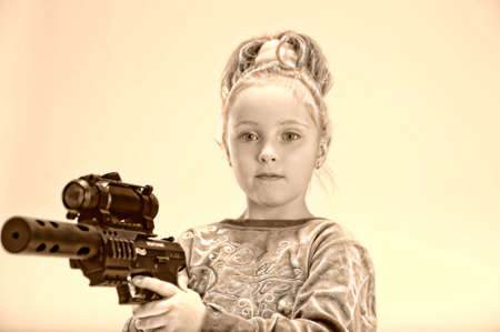 little blond girl with guns, in the studioの写真素材