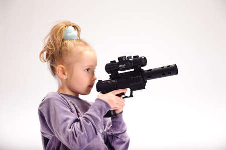 little blond girl with guns, in the studioの写真素材