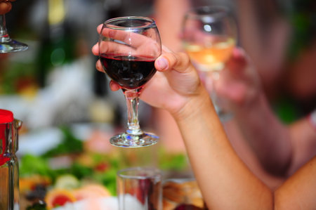 hands holding glasses of wine at the festive table close upの写真素材