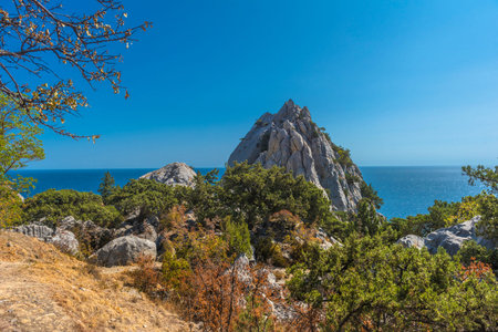 Rock Diva on beach, beautiful black sea shore landscape with mountain cliff, main nature landmark in...