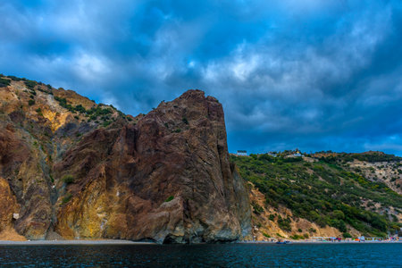 rocks of Cape Fiolent against the background of the evening sky with clouds view from the water