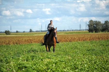 summer teenager girl with a horse in the field