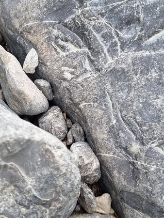 close-up of Crimean pebbles: rounded stones of different colors, shapes and structures. The surface...