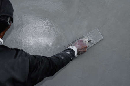 plasterer concrete worker at wall of house constructionの写真素材