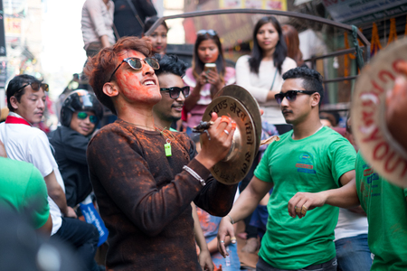 Young man celebrating Diwali / Deepwali / Tihar with friends dancing while banging symbols to music in a street in Kathmanduのeditorial素材