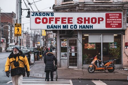 Toronto, ON Canada 12/27/19: Busy street scene of coffee shop and pedestrians on a gritty section of Queen St.のeditorial素材