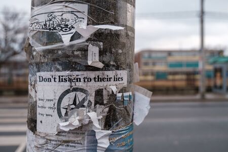Toronto, ON Canada 12/27/2019:  Ripped up anti-war poster on electric pole.のeditorial素材
