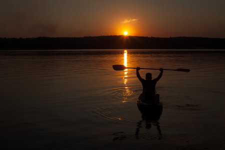 Kayak silhouette in sunsetの写真素材